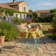 Round yellow oilcloth tablecloth with colorful floral patterns on a bistro table in a garden - Casa Frida