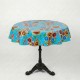 Round yellow oilcloth tablecloth with colorful floral patterns on a bistro table in a garden - Casa Frida
