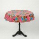 Round yellow oilcloth tablecloth with colorful floral patterns on a bistro table in a garden - Casa Frida